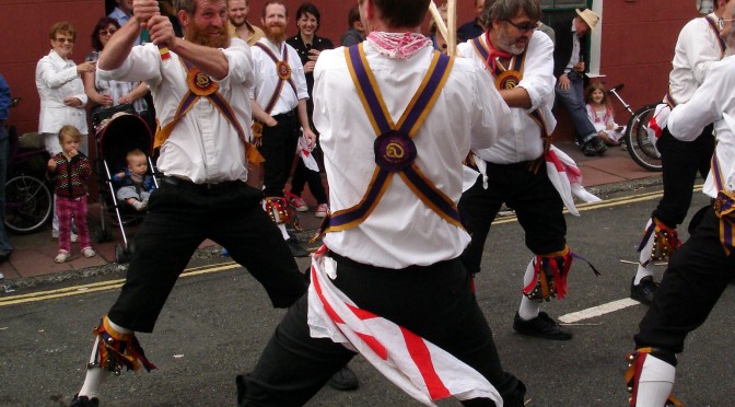 Image of dancers with sticks, about to break