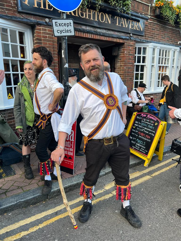 A Brighton Morris dancer leans casually on a Morris stick outside the Brighton Tavern during our North lain Tour. 11th May.